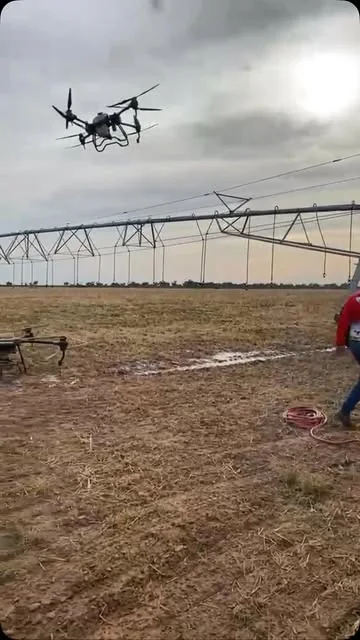 Dron de Droneteam en vuelo junto a un pivot de riego, con el equipo en el lote